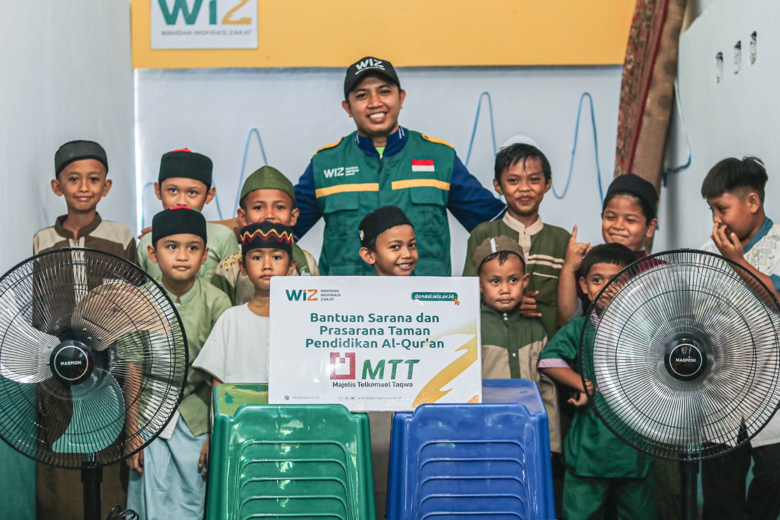Relawan WIZ berpose dengan santri Rumah Qur'an Al-Khairat beserta dengan bantuan sarana dan prasana pendukung belajar-mengajar.