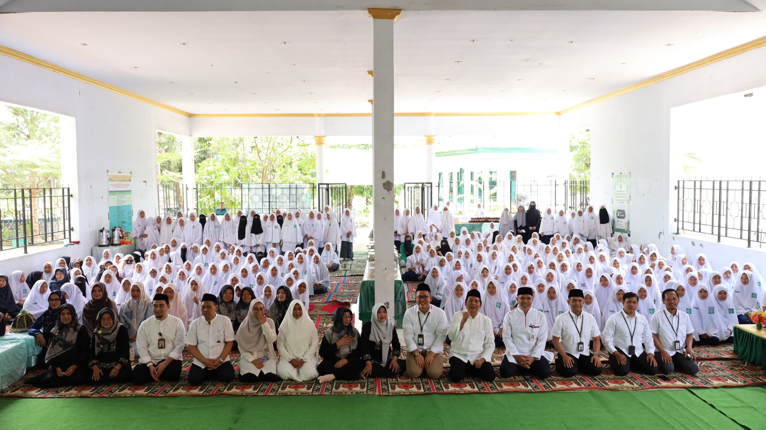 Keluarga Besar Pesantren Putri Yatama berpose bersama jajaran BSI Makassar dan OJK Sulselbar.