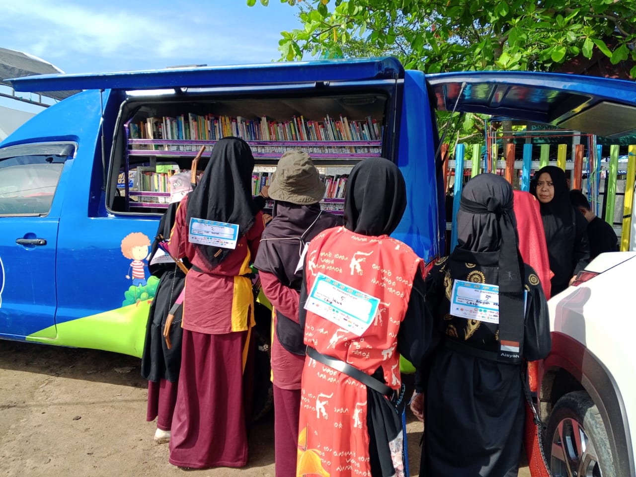 Sejumlah atlet remaja menyempatkan mampir melihat-lihat buku di mobil perpustakaan keliling di samping lokasi pertandingan panahan tradisional  di Sekolah Alqur'an Wahdah Islamiyah 02, Kota Makassar, pada Ahad, 20 November 2024.
