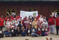 Pegiat Kolaborasi Dakwah Pelosok berpose bersama dengan para anak-anak penerima wakaf Alqur'an.