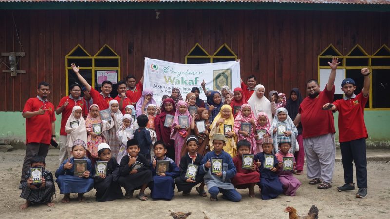 Pegiat Kolaborasi Dakwah Pelosok berpose bersama dengan para anak-anak penerima wakaf Alqur'an.