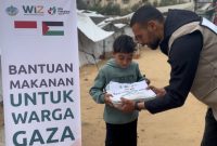 Seorang relawan memberikan makanan kepada seorang anak di Gaza Utara, Palestina. 