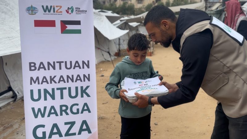 Seorang relawan memberikan makanan kepada seorang anak di Gaza Utara, Palestina. 